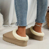 Women's black shearling fuzzy lined platform loafers worn with denim jeans, showcasing the stylish and comfortable footwear on a human leg.