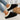 Women's black shearling fuzzy lined platform loafers worn by a person dressed in fashionable clothing.