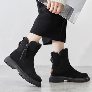 Women's black suede fur-lined ankle boots designed for winter, featuring a non-slip sole. The boots are paired with denim jeans, showcasing a fashionable cold-weather look.