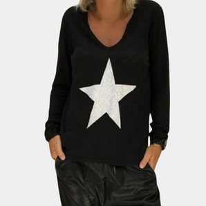 Black V-neck sweater with sequin star design, worn by a person, showcasing the long sleeves and fitted waist.
