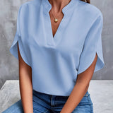 Women's black v-neck blouse with split sleeves, styled as an elegant summer work top.