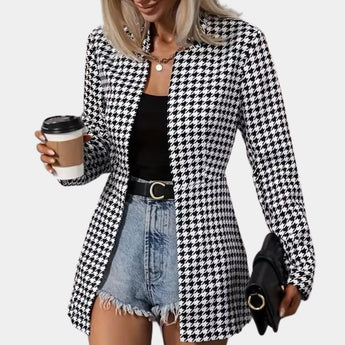 Women's black and white houndstooth blazer with tartan pattern, featuring long sleeves and a tailored fit, styled with a dress shirt underneath, suitable for office wear.