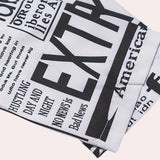 Women's trench coat with a black and white newspaper print design featuring various fonts and graphics, long sleeves, and a classic monochrome pattern.