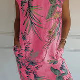 
A plus-size, pink floral dress featuring a tropical print, with short sleeves and a lightweight fabric, designed as a tunic-style one-piece garment.