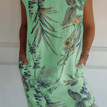Women's green floral knee-length dress, featuring a lightweight fabric ideal for summer. The dress is styled as a tunic with a comfortable fit, showcasing a one-piece design. The image highlights the shoulder and arm features, and the green color is prominent throughout the garment.
