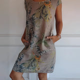 Women's blue floral knee-length summer tunic dress, worn by a model showcasing the dress's lightweight fabric and comfortable fit, with focus on the one-piece garment design, arm and shoulder details, and knee-length hem.
