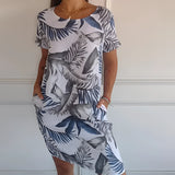Women's blue floral knee-length dress featuring a lightweight summer tunic design, shown in size 5XL. The dress has short sleeves, a round neckline, and a flattering fit around the waist. The model is smiling, showcasing the dress's comfortable and stylish look.