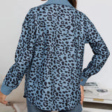 
A women's blue leopard print shirt with long sleeves and a stylish design, paired with jeans. The shirt features a chic animal print pattern, suitable for casual or semi-formal wear.