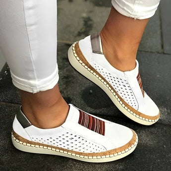 Women's blue suede slip-on shoes featuring a perforated upper with a colorful band, complemented by a white sole.