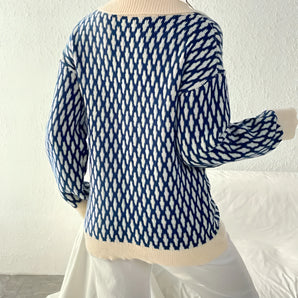 Women's blue and white houndstooth crewneck sweater in retro knitwear style, featuring long sleeves and a classic pattern.
