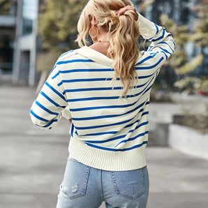 
A woman wearing a blue and white nautical striped sweater with a casual crew neck pullover design. She is standing with arms relaxed, showcasing the sweater's fit around the shoulders, sleeves, and waist. She is also wearing eyewear.