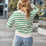 A woman wearing a blue and white striped lightweight pullover sweater, with visible shoulder and sleeve details, styled casually.