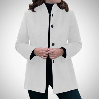 Elegant women's blue wool coat tailored for winter, featuring a sophisticated design. The model is showcasing the coat with attention to details such as the shoulder and sleeve fitting.