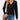 A woman wearing a black cable knit turtleneck sweater, suitable for fall fashion. The sweater features long sleeves and a cozy, textured design, paired with jeans.