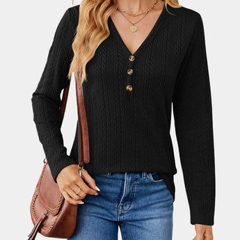 A woman wearing a black cable knit turtleneck sweater, suitable for fall fashion. The sweater features long sleeves and a cozy, textured design, paired with jeans.