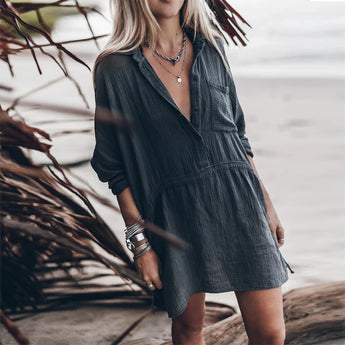 Woman wearing a dark blue 3XL bohemian V-neck beachwear dress with short sleeves and lightweight fabric, accessorized with a wide-brim hat and sunglasses, standing outdoors.