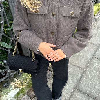 Women's brown corduroy oversized jacket displayed on a mannequin, emphasizing its trendy casual urban style with distinctive shoulder and sleeve features. The jacket is paired with a black dress shirt underneath, showcasing a fashionable layering option.