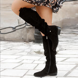 Women's brown suede slouchy knee-high boots in a bohemian fall style, featuring a small hook detail. The boots are showcased on a fashion model, highlighting their knee-high length and stylish design.