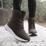 Women's brown waterproof insulated high-top snow boots shown outdoors in a snowy setting, highlighting their stylish design suitable for winter conditions.