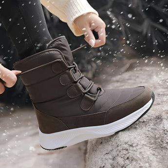 Women's brown waterproof insulated high-top snow boots displayed outdoors, showcasing their stylish design suitable for winter weather.