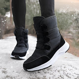 Women's brown waterproof insulated high-top snow boots worn by a person standing outdoors in the snow near a tree. The boots are designed for cold weather and provide style and protection.