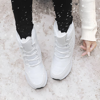 Women's brown waterproof insulated high-top snow boots worn by a person, showcasing the stylish design and cozy fit on the legs.