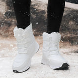 Brown waterproof insulated stylish high-top women's snow boots on a person standing, with a focus on the footwear and textile material.