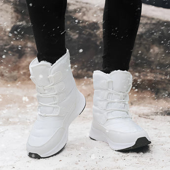 Brown waterproof insulated stylish high-top women's snow boots on a person standing, with a focus on the footwear and textile material.