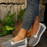 Women's brown wedge loafers styled as casual sneakers on a person's feet, shown on grass background.