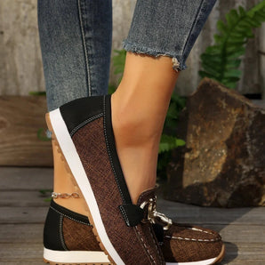 Women's brown wedge loafers styled as casual sneakers, showcasing a sleek design with a raised heel.
