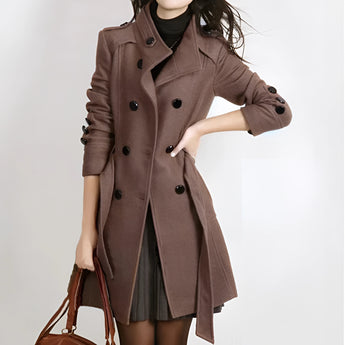 Women's brown wool double-breasted trench coat in size 4XL featuring a stylish design suitable for winter wear, showcasing long sleeves, a structured collar, and a knee-length hem. The model is standing to display the coat's classic fit and elegant textile.