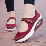 Women's burgundy mesh Mary Jane sneakers with comfortable air cushion, shown on a model's foot wearing a white dress, highlighting the shoe's purple hue and textile material.