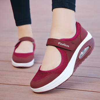Women's burgundy mesh Mary Jane sneakers with comfortable air cushion, shown on a model's foot wearing a white dress, highlighting the shoe's purple hue and textile material.