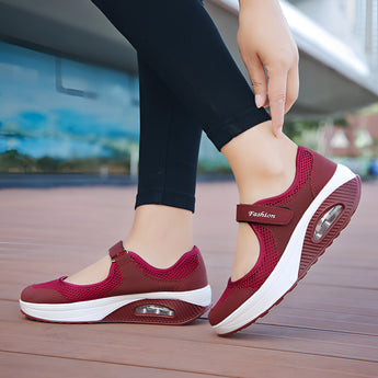 Women's burgundy mesh Mary Jane sneakers with comfortable air cushion design being worn, showcasing their stylish and supportive fit.