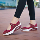 Women's burgundy mesh Mary Jane sneakers with comfortable air cushion, highlighting the stylish design and breathable material, showcased on a model's foot.