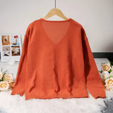Burnt orange V-neck sweater for women, featuring a soft knit fabric with a relaxed fit, displayed on a clothes hanger.