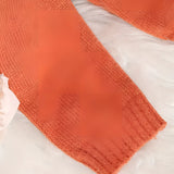 Women's burnt orange v-neck sweater in a soft knit fabric, featuring a relaxed fit and long sleeves.