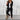 Women's business casual blazer and trousers set in monochrome, featuring a tailored fit with a structured collar, long sleeves, and a flattering waistline. The model is wearing eyewear and the outfit is in a size XL, showcasing a professional and stylish appearance.