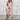 Alt Text: Woman wearing a pink XL business casual blazer and trousers set with a sleek design, featuring a tailored collar, long sleeves, and a dress shirt. She is posing as a fashion model, showcasing the monochrome outfit.