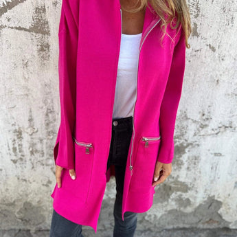 
A woman wearing a pink lightweight wool fall jacket, showcasing a casual chic outerwear style. The coat features a collar, tailored waist, and long sleeves.