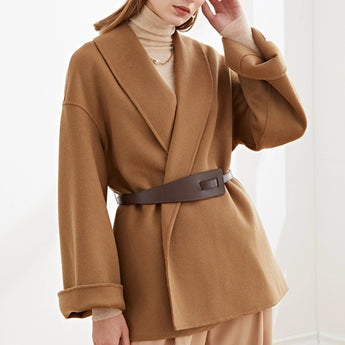 
A women's camel wool coat in an oversized fit, featuring a minimalist design with a chic look. The coat is in a beige color, highlighting its long sleeves and structured shoulder, and is suitable for winter wear.