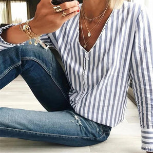 
A women's casual blue striped button-down blouse, showcasing a spring fashion style with a dress shirt design. The blouse features long sleeves and a collar, paired with jeans, emphasizing a relaxed casual look.