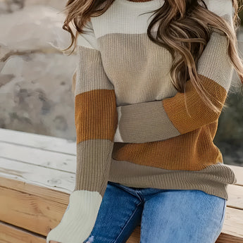 Women's color-blocked cozy knit sweater featuring a trendy tri-color design with sections of white and other complementary shades. The sweater showcases long sleeves and a comfortable fit over the shoulders and neck, creating a stylish look suitable for various body types.