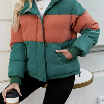 Oversized women's puffer jacket featuring a color-blocked design with green and orange panels, displayed on a mannequin with emphasis on the collar, sleeves, and waist.