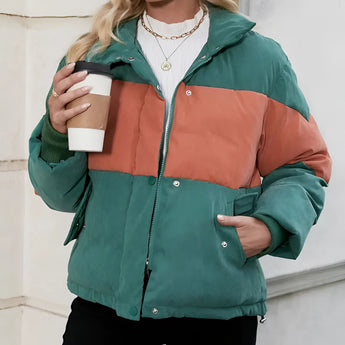 Oversized puffer jacket for women in a green and orange color-blocked design, featuring long sleeves and a high neck.