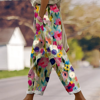 
A woman wearing colorful wide-leg bohemian floral pants in a multicolor design, posing outdoors in nature. The pants are styled for summer fashion and are featured in size 3XL.