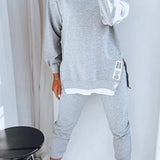
A woman wearing a comfy grey loungewear set, consisting of a sweatshirt and joggers. The outfit is in a large 5XL size and showcases a casual, relaxed style perfect for lounging. The grey color provides a neutral and versatile look.