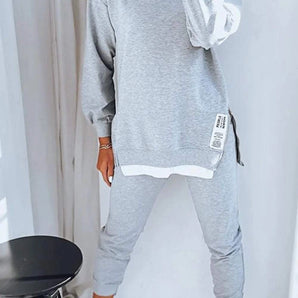 
A woman wearing a comfy grey loungewear set, consisting of a sweatshirt and joggers. The outfit is in a large 5XL size and showcases a casual, relaxed style perfect for lounging. The grey color provides a neutral and versatile look.