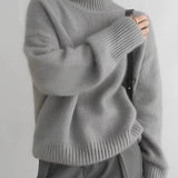Women's oversized cashmere turtleneck sweater in gray, featuring a cozy and relaxed fit with long sleeves, made from soft textile material.