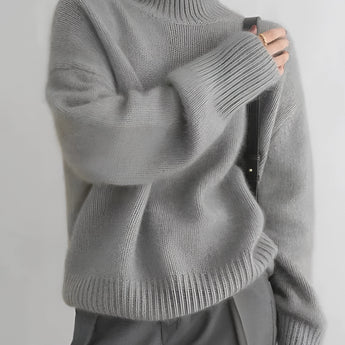 Women's oversized cashmere turtleneck sweater in gray, featuring a cozy and relaxed fit with long sleeves, made from soft textile material.